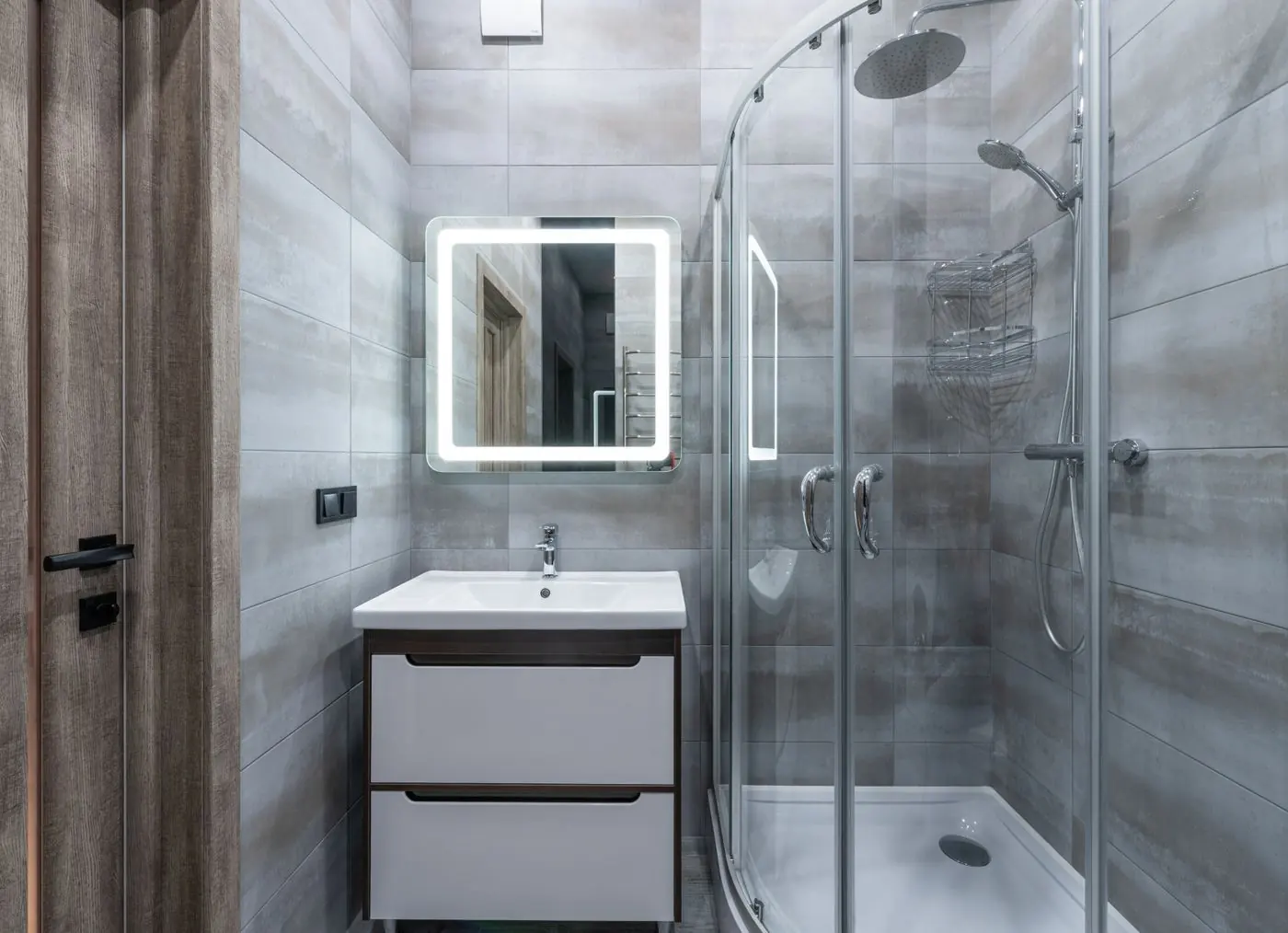 Moderne badkamer met glazen douchecabine en verlichte spiegel